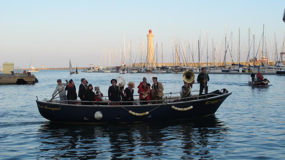 musiciens joyeux dans une barque au milieu d'un port